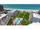 Stunning aerial of a beachfront complex, featuring a community pool, a bridge to beach access, and green spaces at 1465 Gulf Of Mexico Dr # 502, Longboat Key, FL 34228