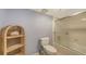 Neutral bathroom features a toilet and shower with sliding glass doors, complemented by woven shelving at 1465 Gulf Of Mexico Dr # 502, Longboat Key, FL 34228