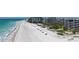 Serene beach setting with chairs and umbrellas next to condos and beach bridge access at 1465 Gulf Of Mexico Dr # 502, Longboat Key, FL 34228
