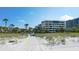 Scenic beach access pathway leading to beachfront condos, framed by palm trees and dune vegetation at 1465 Gulf Of Mexico Dr # 502, Longboat Key, FL 34228
