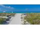 Picturesque beach access with white sand, clear blue water, and beach amenities in a tranquil setting at 1465 Gulf Of Mexico Dr # 502, Longboat Key, FL 34228