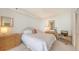 Bright bedroom featuring a bed with white linens, rattan furniture, and ample natural light from the windows at 1465 Gulf Of Mexico Dr # 502, Longboat Key, FL 34228