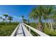 Scenic boardwalk leading to a pristine beach with palm trees at 1465 Gulf Of Mexico Dr # 502, Longboat Key, FL 34228