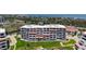 Multi-story condo building featuring private balconies with shaded awnings and manicured green spaces at 1465 Gulf Of Mexico Dr # 502, Longboat Key, FL 34228