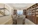 Elegant library featuring built-in bookshelves and a large table for gatherings at 1465 Gulf Of Mexico Dr # 502, Longboat Key, FL 34228