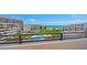 Scenic view from the balcony showcases a pool, lawn, and the ocean at 1465 Gulf Of Mexico Dr # 502, Longboat Key, FL 34228