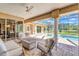 Outdoor patio featuring modern white lounge furniture, fire pit, fan, and lake view at 15006 21St E Ave, Bradenton, FL 34212