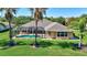 Home exterior featuring a screened in pool area, with manicured lawn, and palm trees at 15006 21St E Ave, Bradenton, FL 34212