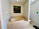 Bathroom featuring a tiled, soaking tub with tile surround, a toilet, and a nature-themed art piece at 15207 Searobbin Dr, Lakewood Ranch, FL 34202