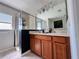 Bathroom features a double sink vanity with wooden cabinets and framed glass shower at 15207 Searobbin Dr, Lakewood Ranch, FL 34202