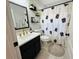 Updated bathroom features a single sink vanity with matte black hardware and a pineapple patterned shower curtain at 15207 Searobbin Dr, Lakewood Ranch, FL 34202