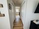 Hallway featuring laminate flooring, white trim, and views to the main bedroom at 15207 Searobbin Dr, Lakewood Ranch, FL 34202