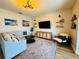 Bright living room featuring modern decor, light colored sofa, accent chair, and a media center at 15207 Searobbin Dr, Lakewood Ranch, FL 34202