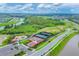 An aerial view of a community park with tennis courts, baseball field, playground, and lush green space at 17122 Ranchside Pl, Bradenton, FL 34211
