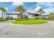 A landscaped roundabout leads to the covered entrance of Star Farms, lined with palms and stone accents at 17122 Ranchside Pl, Bradenton, FL 34211