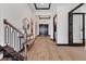 Elegant foyer featuring a wood-look tile floor, modern lighting and a staircase with metal railing at 17122 Ranchside Pl, Bradenton, FL 34211