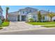 Beautiful two-story home featuring a three-car garage, stone accents, and professionally landscaped yard at 17122 Ranchside Pl, Bradenton, FL 34211