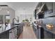 Modern kitchen with black cabinets, stainless appliances, and a breakfast bar that opens to the dining area with a beautiful view at 17122 Ranchside Pl, Bradenton, FL 34211