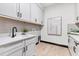 Well-appointed laundry room with white cabinets, sink, and modern design at 17122 Ranchside Pl, Bradenton, FL 34211