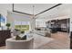 Open-concept living room with lake views, modern lighting, and access to the dining area and kitchen at 17122 Ranchside Pl, Bradenton, FL 34211