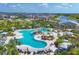 A high-angle shot showcases a spacious pool, accompanied by lounging areas, mature landscaping, and a nearby Palm Bar at 17122 Ranchside Pl, Bradenton, FL 34211
