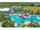 An aerial shot capturing the inviting pool with its vibrant blue water, set amongst tropical trees and comfortable lounge seating at 17122 Ranchside Pl, Bradenton, FL 34211