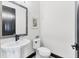 Stylish half bath with a pedestal sink, decorative mirror, and modern fixtures at 17122 Ranchside Pl, Bradenton, FL 34211
