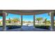 An open-air view of the pool through the clubhouse's column-lined entryway, complete with palm trees and clear skies at 17704 Gawthrop Dr # 303, Lakewood Ranch, FL 34211