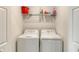 Laundry room with a white washer and dryer, complemented by overhead wire shelving for storage at 17704 Gawthrop Dr # 303, Lakewood Ranch, FL 34211