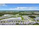 An aerial view of residential development featuring a pond with fountain surrounded by lush green landscape at 18510 Midsummer Pl, Venice, FL 34293
