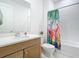 Bathroom with vanity, white countertop, and tub-shower combo with flamingo curtain at 18510 Midsummer Pl, Venice, FL 34293