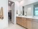 Bathroom features a double vanity, white countertops and a walk-in closet at 18510 Midsummer Pl, Venice, FL 34293
