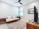 Bedroom with ceiling fan, daybed, area rug, TV, and a neutral color palette at 18510 Midsummer Pl, Venice, FL 34293