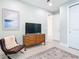Bedroom area with a TV, dresser, comfortable chair and ample closet space at 18510 Midsummer Pl, Venice, FL 34293
