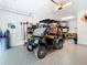 Garage with epoxy flooring and a dark green E-Merge golf cart for neighborhood adventures at 18510 Midsummer Pl, Venice, FL 34293