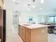 Modern kitchen island featuring a sink, dishwasher, and pendant lighting, with a view of the living area at 18510 Midsummer Pl, Venice, FL 34293