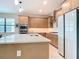 Bright kitchen featuring a center island with a sink and light wood cabinets at 18510 Midsummer Pl, Venice, FL 34293