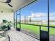 Screened lanai overlooking a serene lake and well-manicured backyard, creating a tranquil outdoor space at 18510 Midsummer Pl, Venice, FL 34293