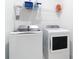 Clean laundry room with a new side-by-side washer and dryer, with shelving at 18510 Midsummer Pl, Venice, FL 34293