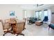 Bright living room featuring a ceiling fan, comfortable seating, and sliding glass doors at 18510 Midsummer Pl, Venice, FL 34293