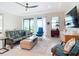 Bright living room with sliding glass doors, a ceiling fan, and comfortable seating at 18510 Midsummer Pl, Venice, FL 34293
