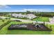 A modern community playground with green slide and sandbox is surrounded by well-manicured green lawns at 18510 Midsummer Pl, Venice, FL 34293