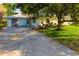 View of the home featuring a spacious driveway, lush lawn, and shade trees at 1921 Fairview Dr, Englewood, FL 34223