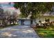 A cozy single-story home features a well-maintained lawn, a driveway, and mature trees offering shade at 1921 Fairview Dr, Englewood, FL 34223