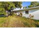 A charming exterior view reveals a light green home with white trim and lush landscaping at 1921 Fairview Dr, Englewood, FL 34223