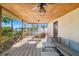 Relaxing screened porch with wood ceiling, fan, and charming lattice, offering serene views of the waterfront at 1921 Fairview Dr, Englewood, FL 34223