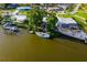 Waterfront property with a dock and a sailboat anchored in the serene canal, surrounded by lush greenery and nearby homes at 1921 Fairview Dr, Englewood, FL 34223