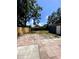 Large backyard featuring a wooden fence, mature trees, and spacious patio area at 1947 Los Lomas Dr, Clearwater, FL 33763