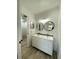 Bright bathroom featuring double sinks, modern fixtures, and round mirrors at 1947 Los Lomas Dr, Clearwater, FL 33763