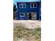 Rear exterior view with sliding glass door and patio, showcasing the blue facade and backyard access at 1947 Los Lomas Dr, Clearwater, FL 33763